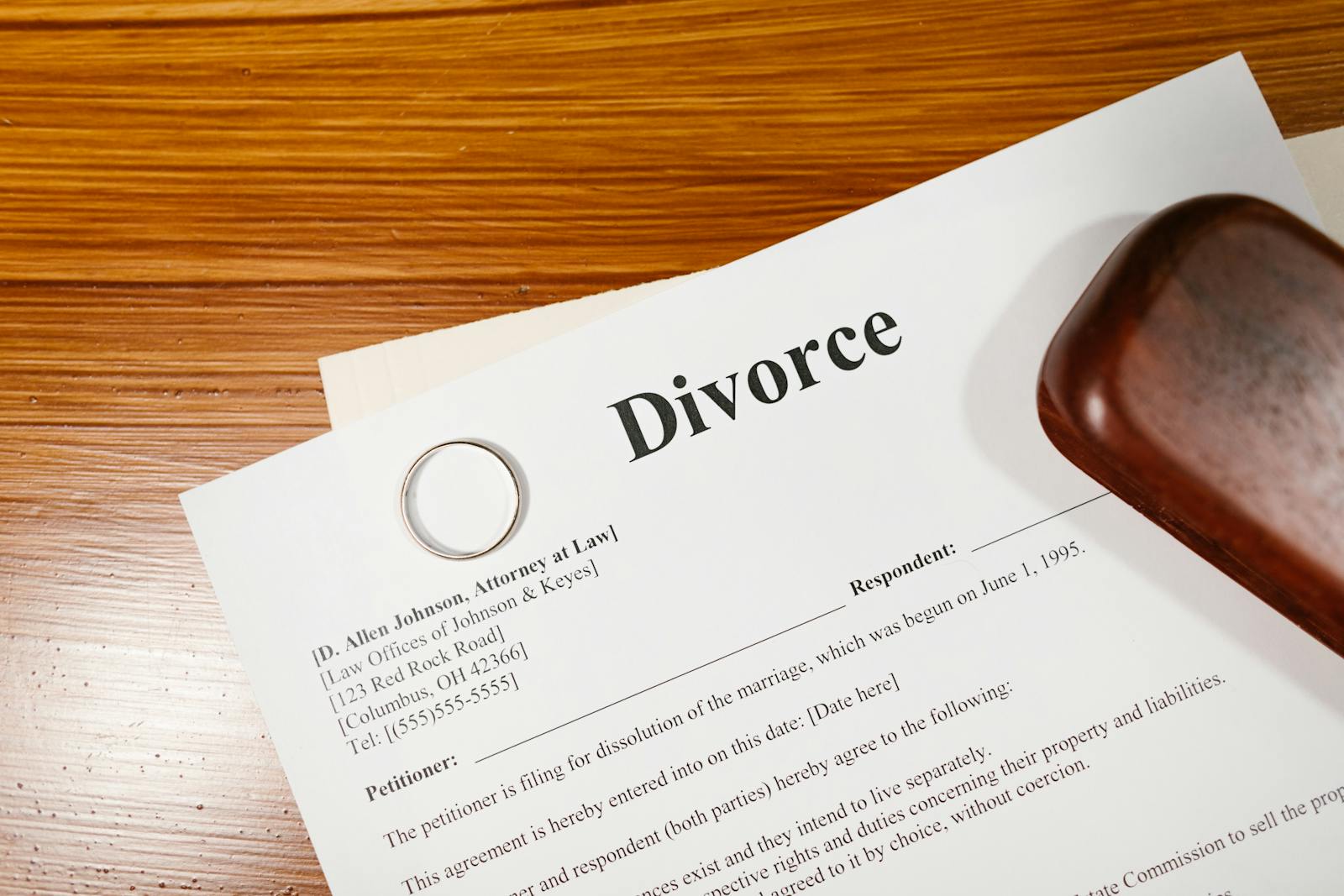 Close-up of a divorce document and wedding ring on a lawyer's desk.